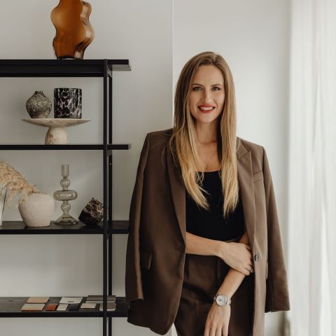Harlow leasing representative in business attire smiling in modern office